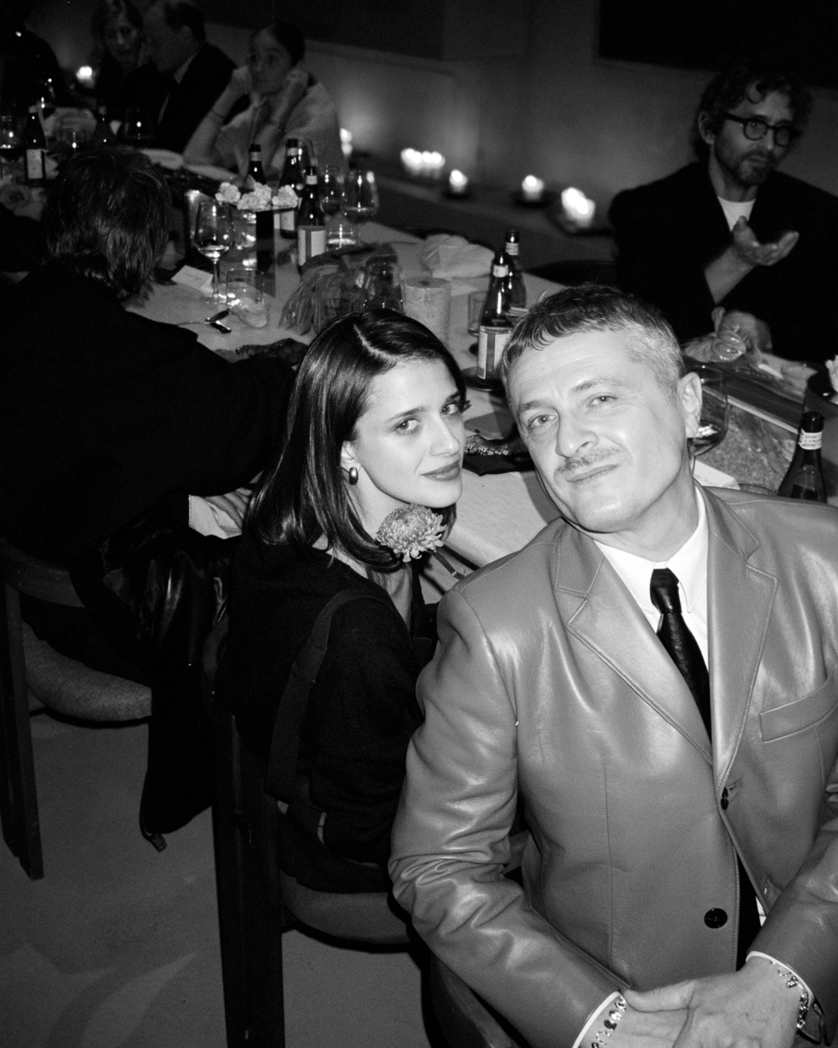 Black-and-white portrait of Benedetta and Federico seated close together at a table, Federico wearing a suit and tie.